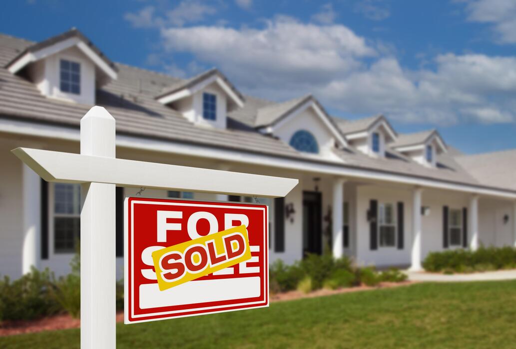 sold-for-sale-real-estate-sign-in-front-of-new-house-photo
