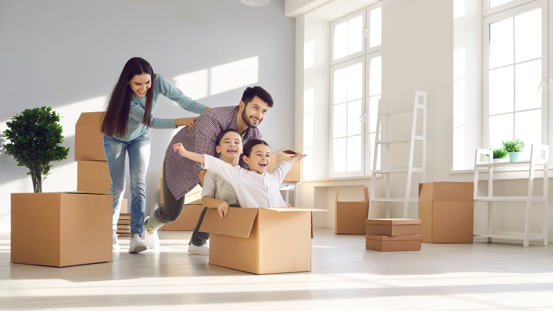 Joyful family with kids having fun in new home