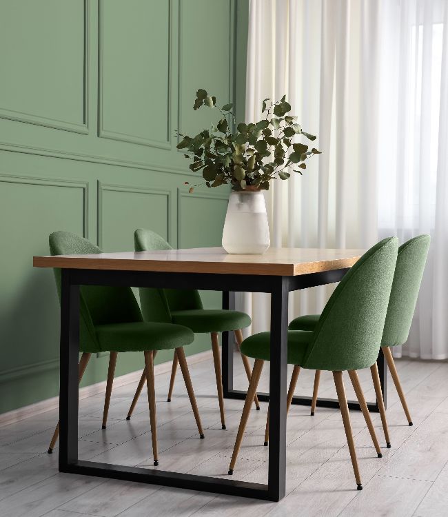 Dining table with chairs near sage green wall indoors(1)