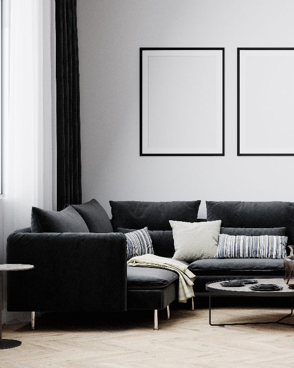 Stylish interior of bright living room with black sofa and armchair, floor lamp and coffee table with decoration(1)