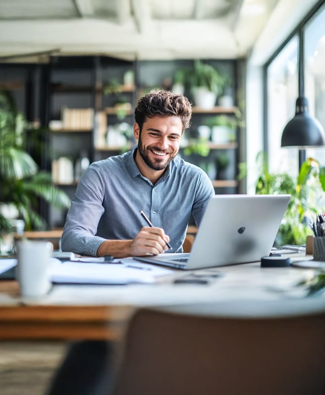 A_young_businessman_writing_on_paper_using_a_l_7e3c3e78-766b-4348-8321-7a9de4bf5c68