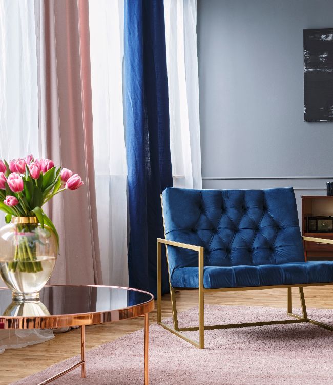 blue, wide chair standing on a rug in a spacious living room interior(1)