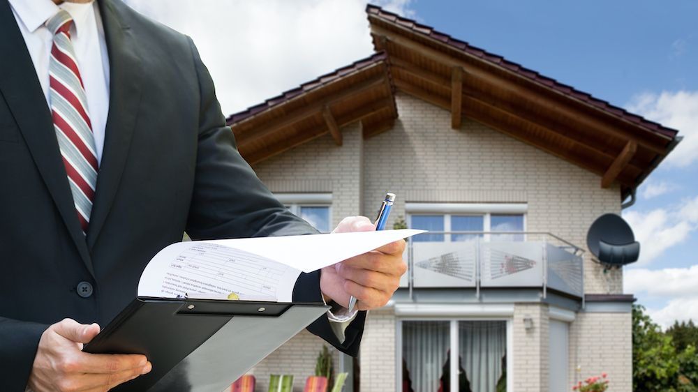 Man Checking Documents Standing Near House