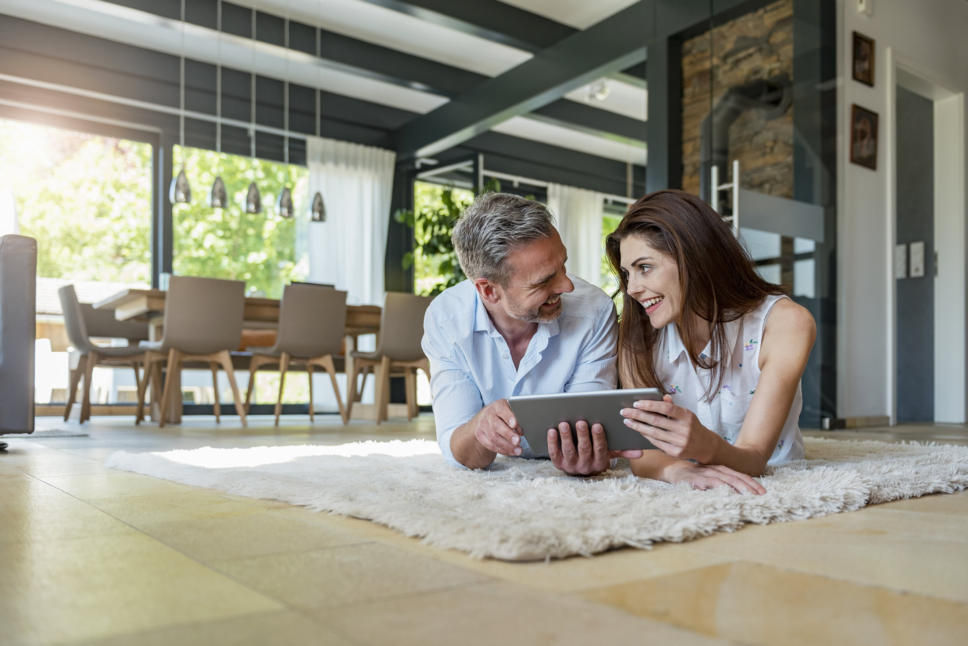 happy-couple-lying-on-carpet-at-home-sharing-a-tab-2024-09-18-02-43-01-utc