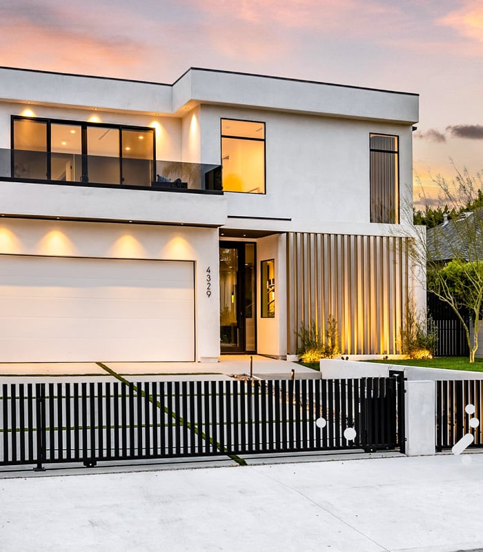 a-big-white-house-with-a-nice-gate-and-some-trees-2025-02-11-19-40-20-utc