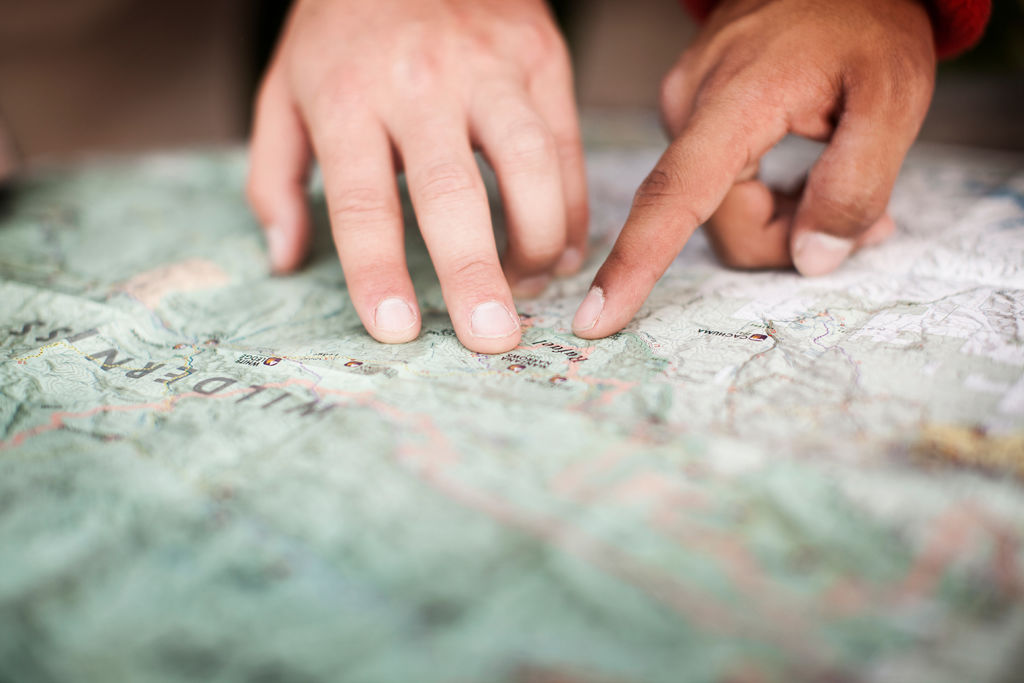 Cropped image of people pointing at map