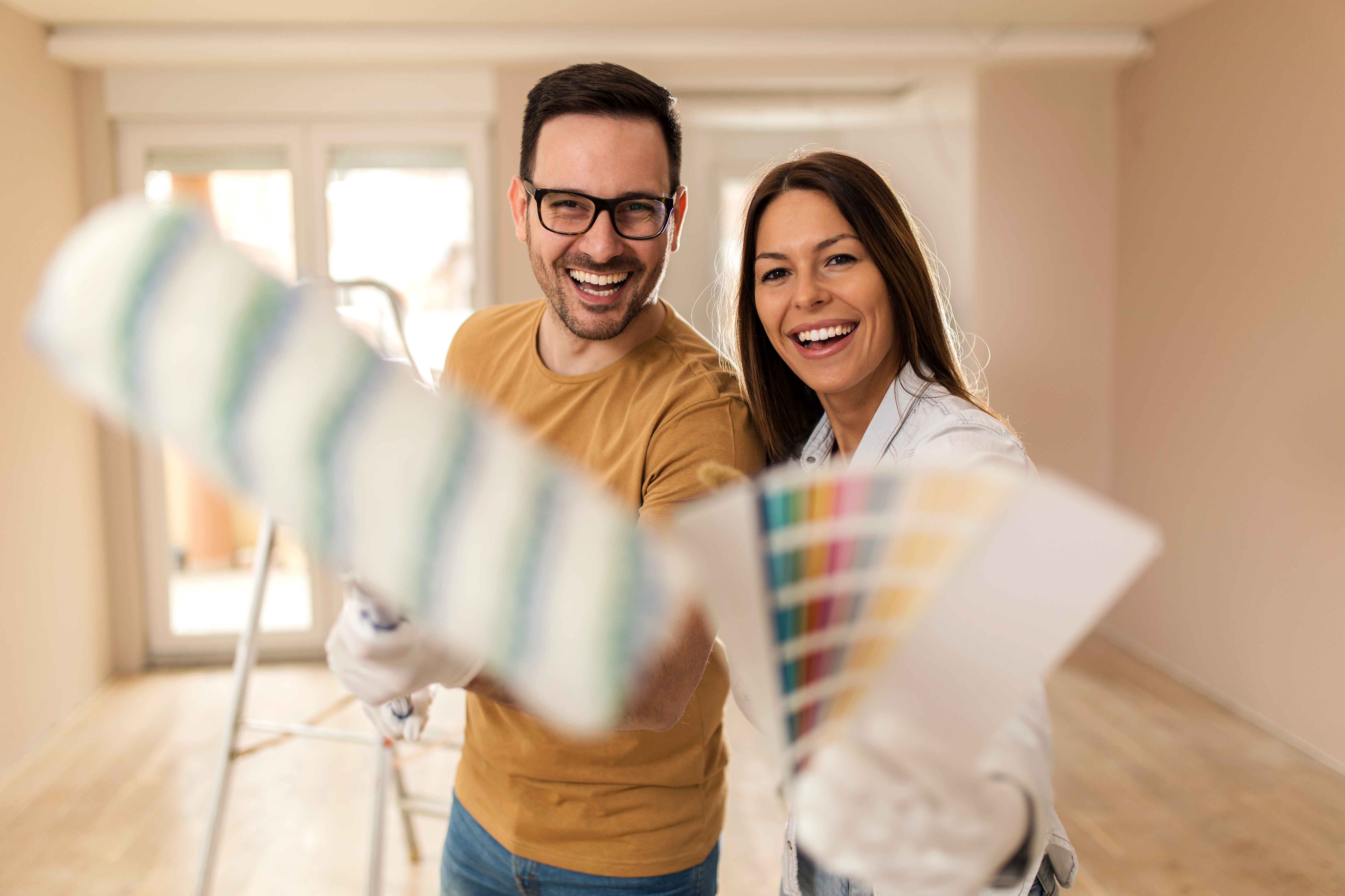 Young couple painting their apartment.