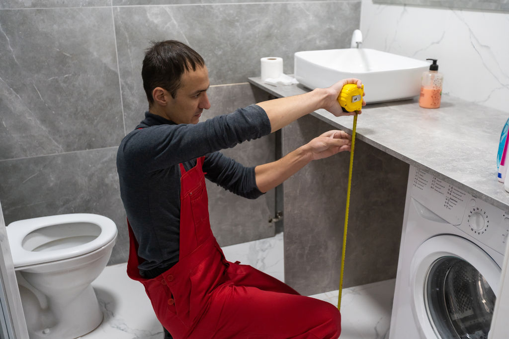 Architect taking measures of a brand new bathroom furniture. Home style and design concepts
