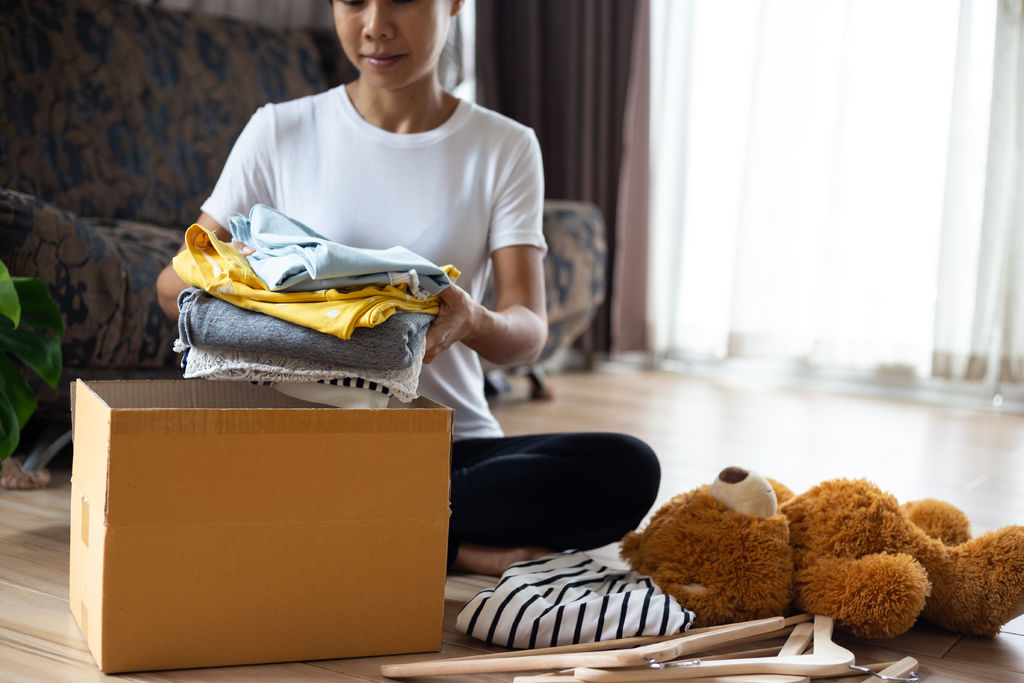 Woman holding Clothes with Donate Box In her room, Donation Conc