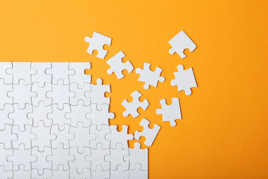 White puzzle on a colored background top view.