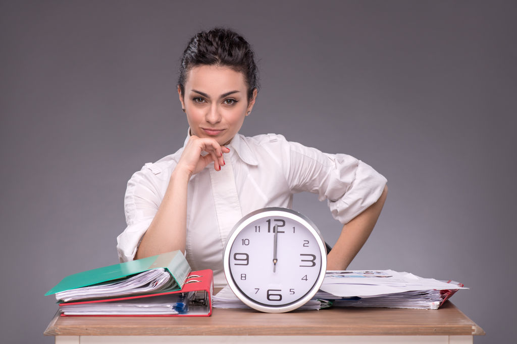 Waist-up portrait of young girl sitting at the table in office