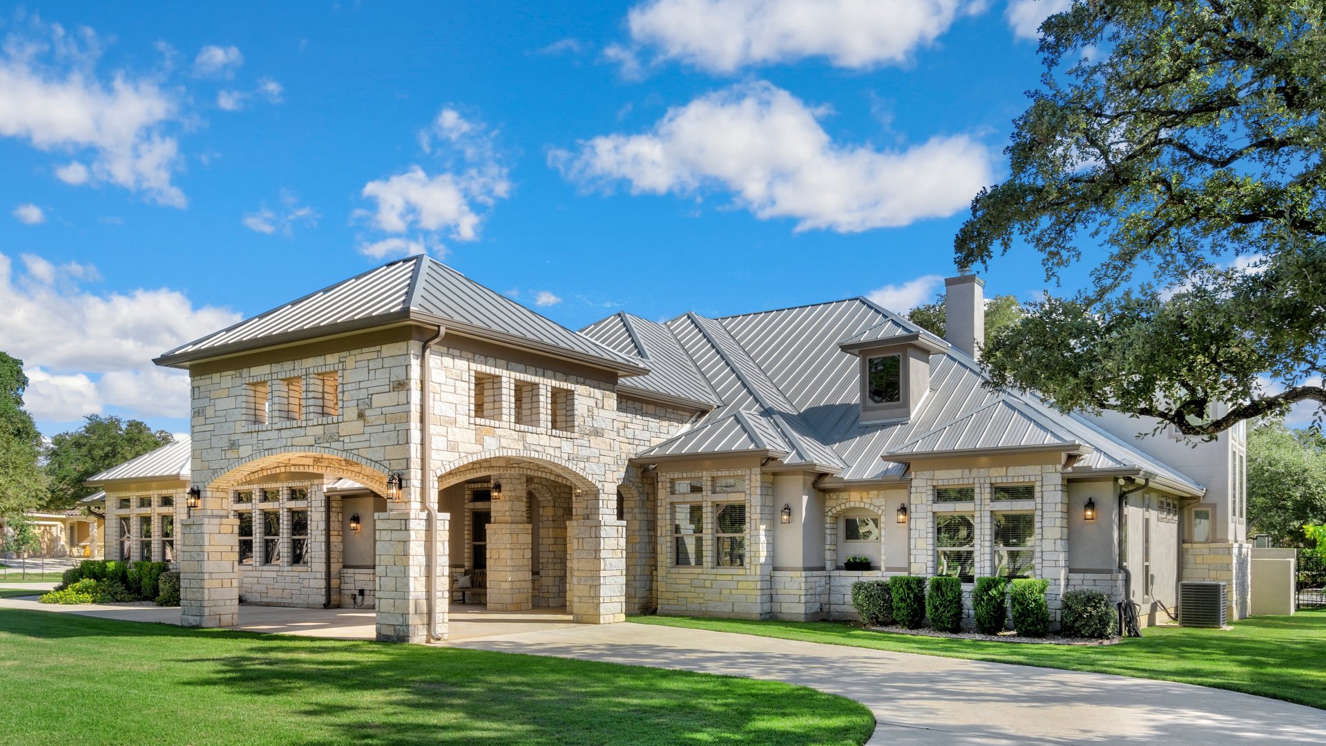 A luxury white home with a green lawn