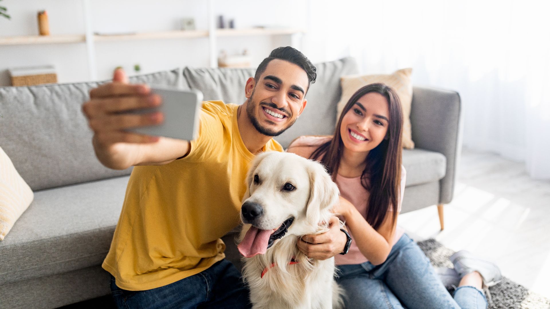 104. Young affectionate multiracial couple taking selfie with pet dog