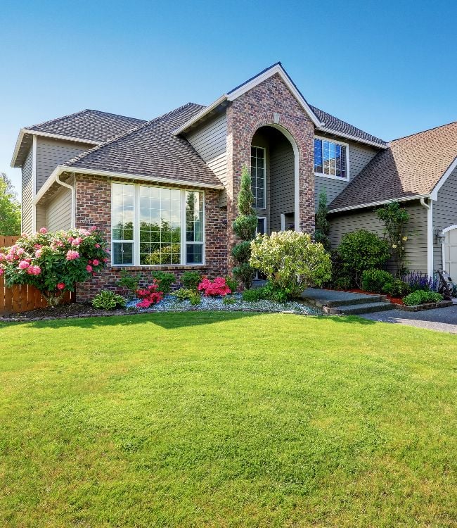 Luxury house exterior with brick and siding trim and double garage. Well kept garden around. Northwest, USA