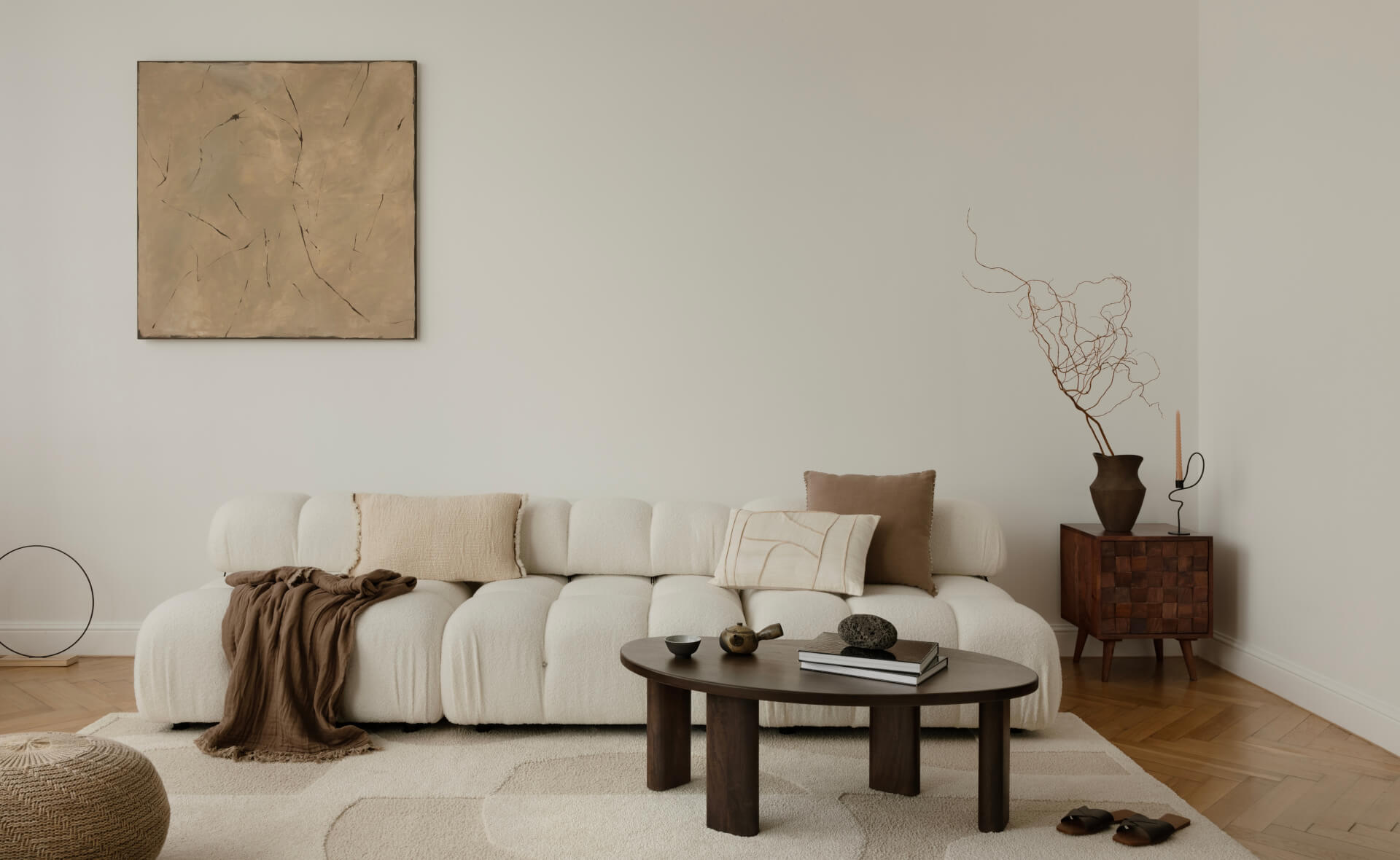 minimalist living room with a plush, white sofa adorned with neutral cushions and a cozy blanket