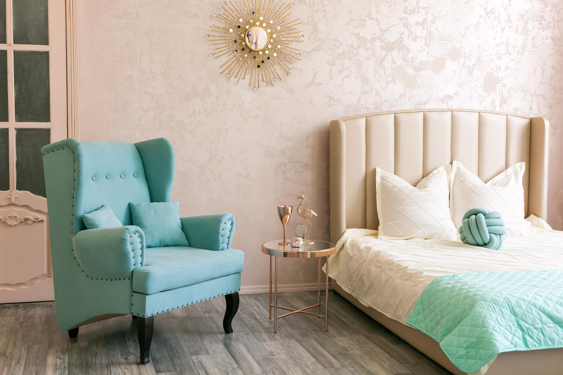 a bright bedroom bedroom in pink, blue and gold colors, blue comfy armchair