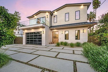 A house with a tiled driveway and lush greenery in the garden. California, USA