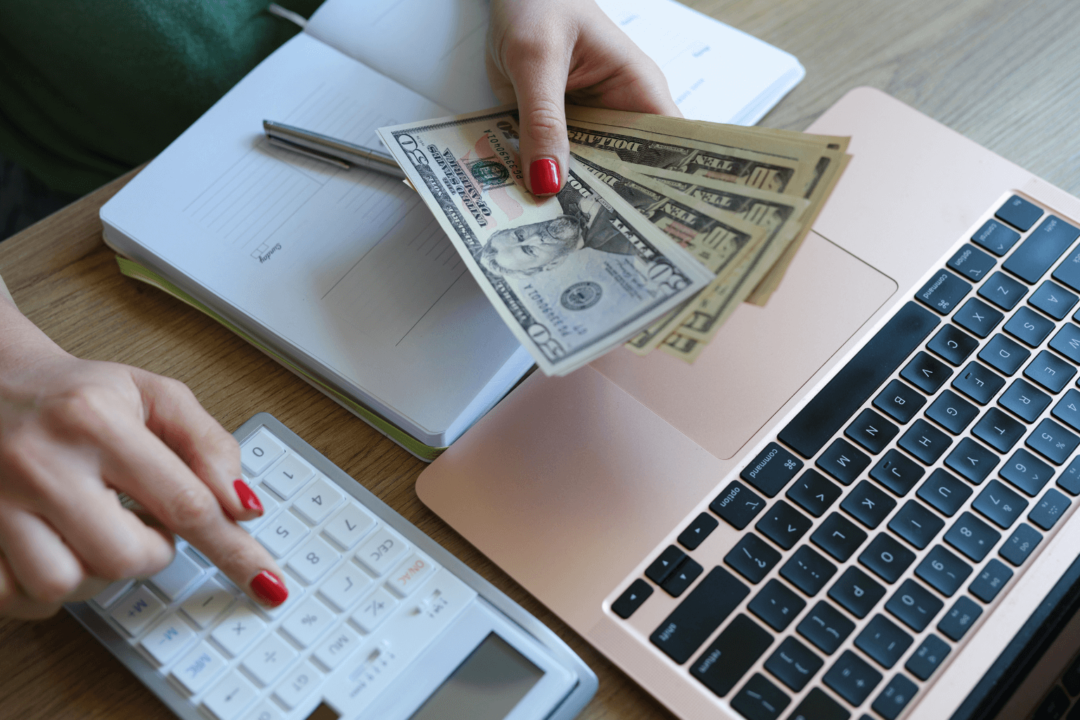 Person using calculator and laptop to plan home budget