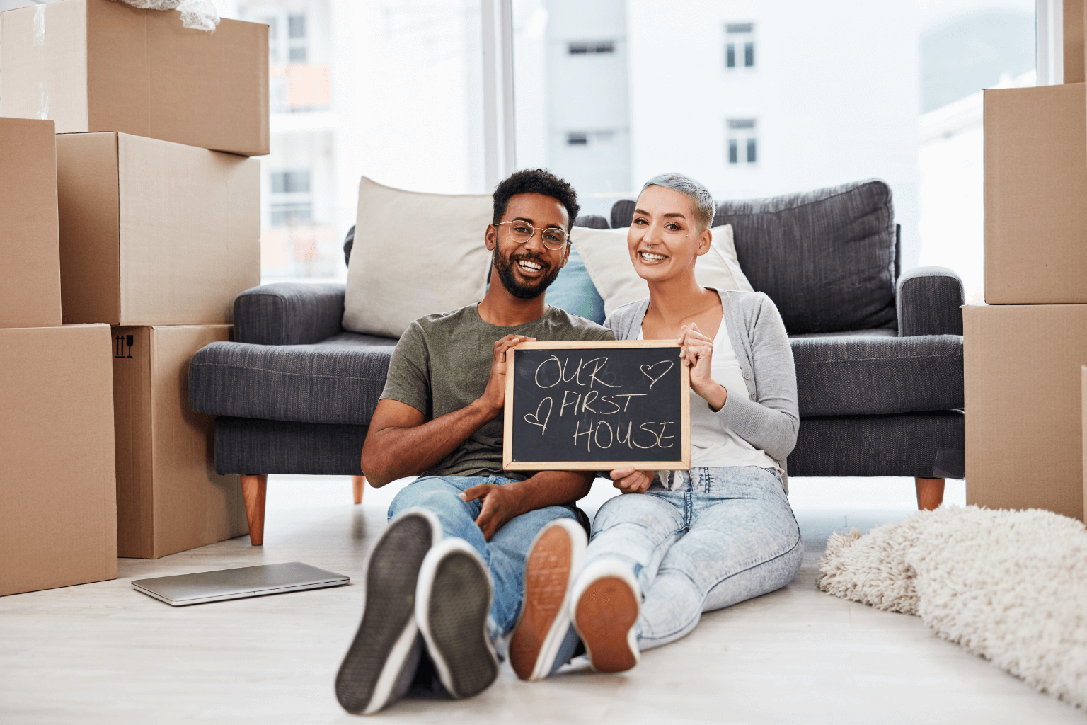 First-time buyers smiling in front of their new house in Moraga
