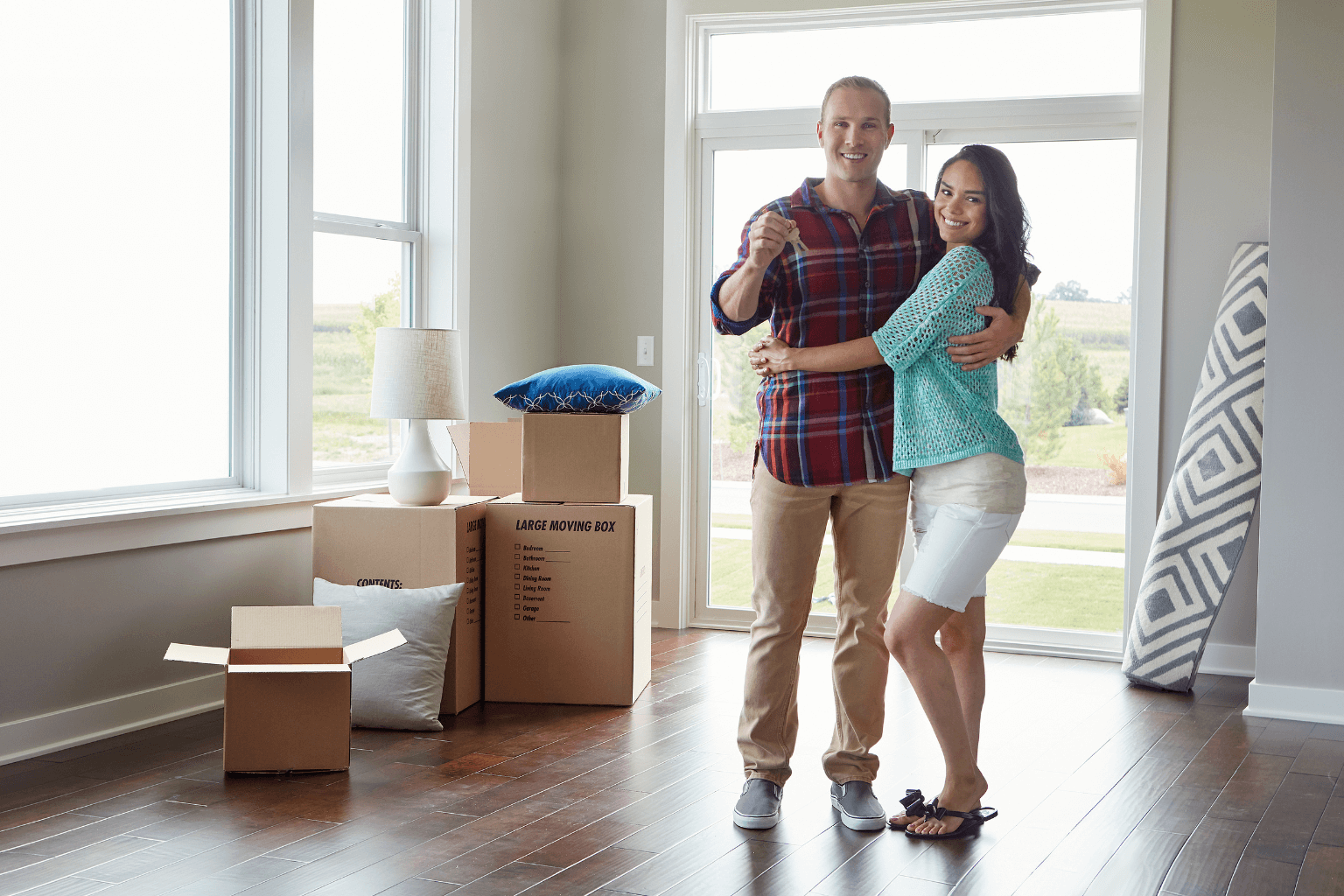 First-time homebuyers celebrating with house keys inside of their new home