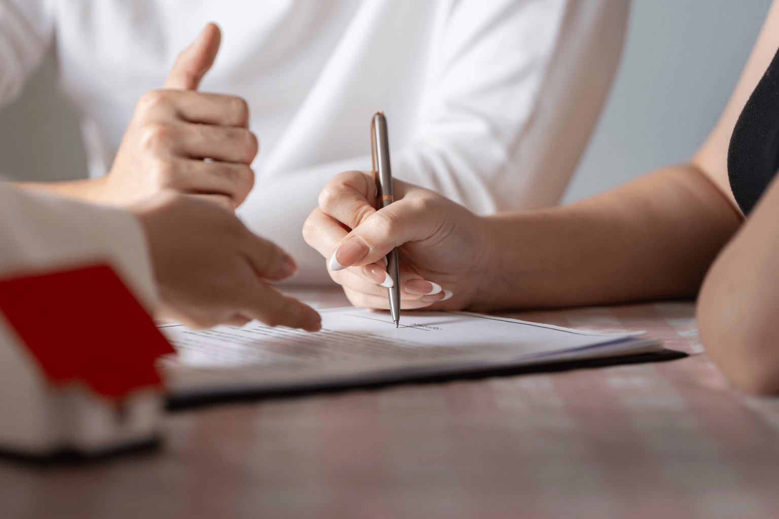 Hands signing real estate paperwork