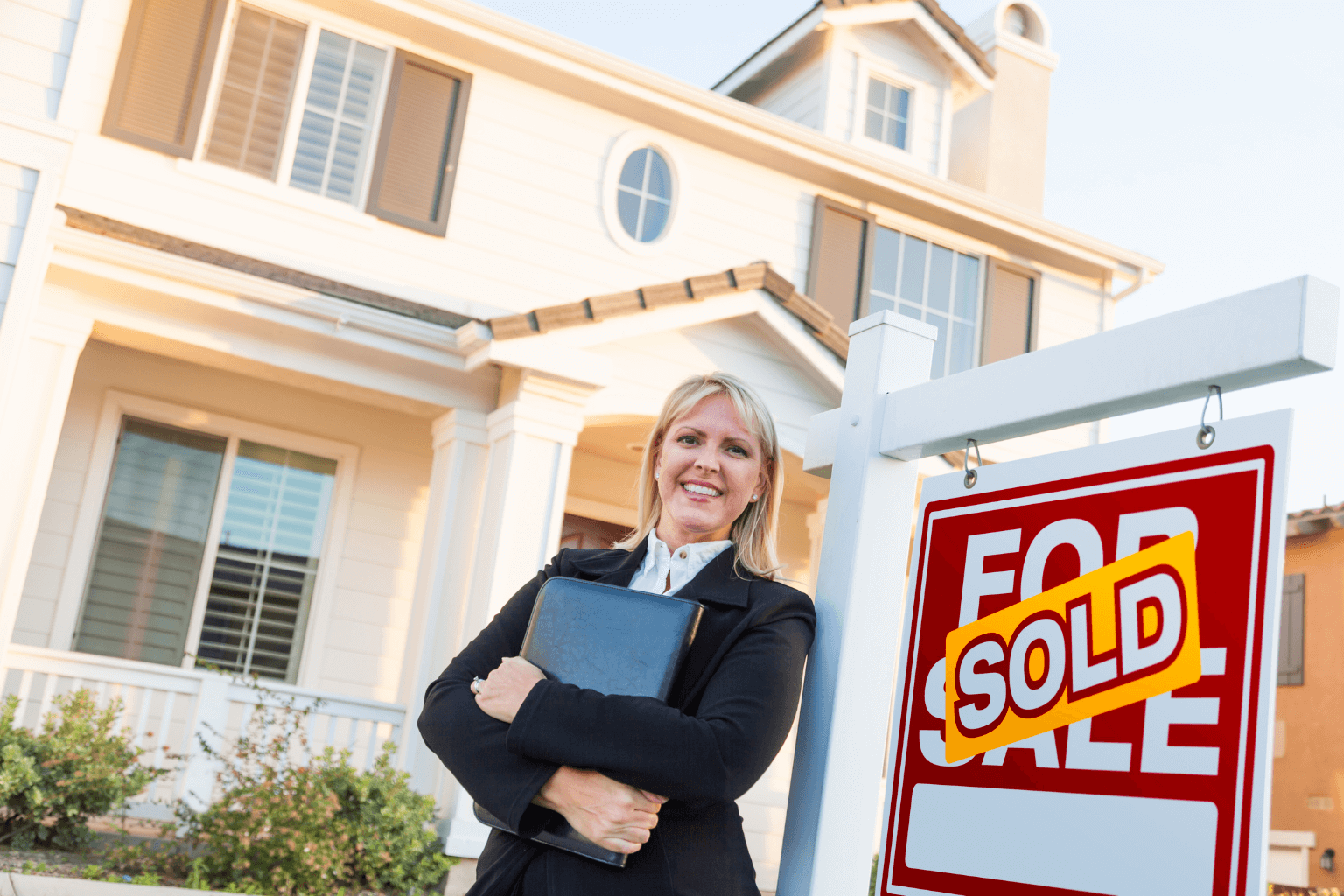 Experienced real estate agent holding a sold sign in front of home