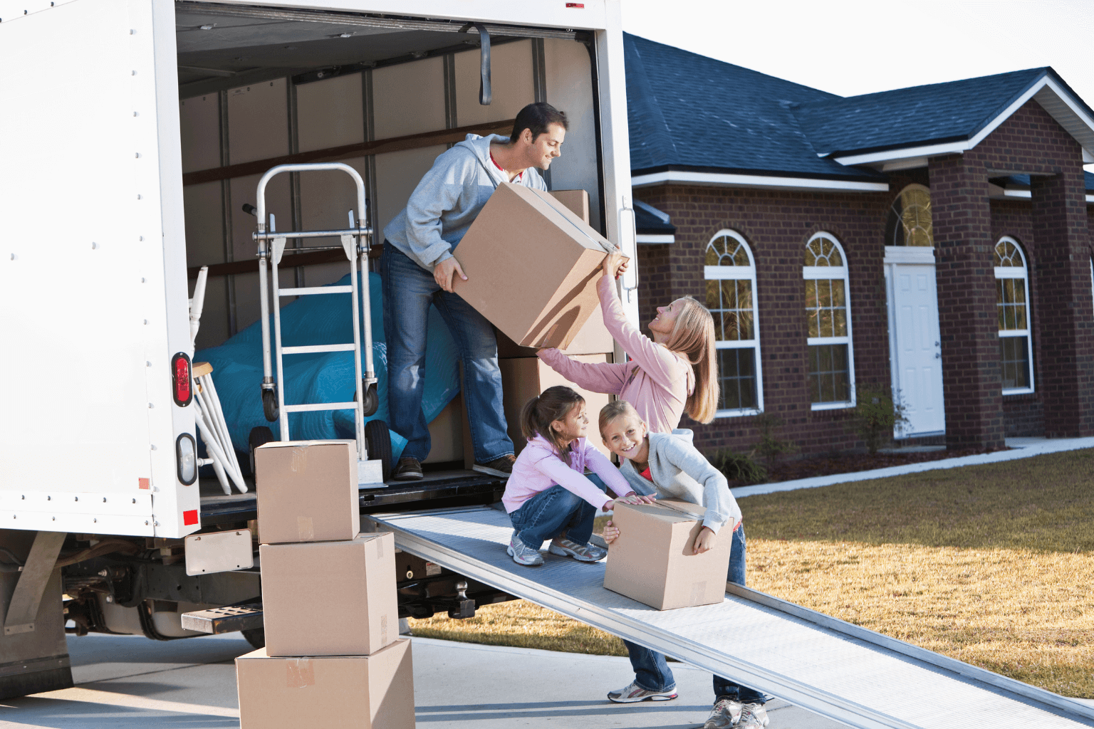 Family holding moving boxes after relocating.