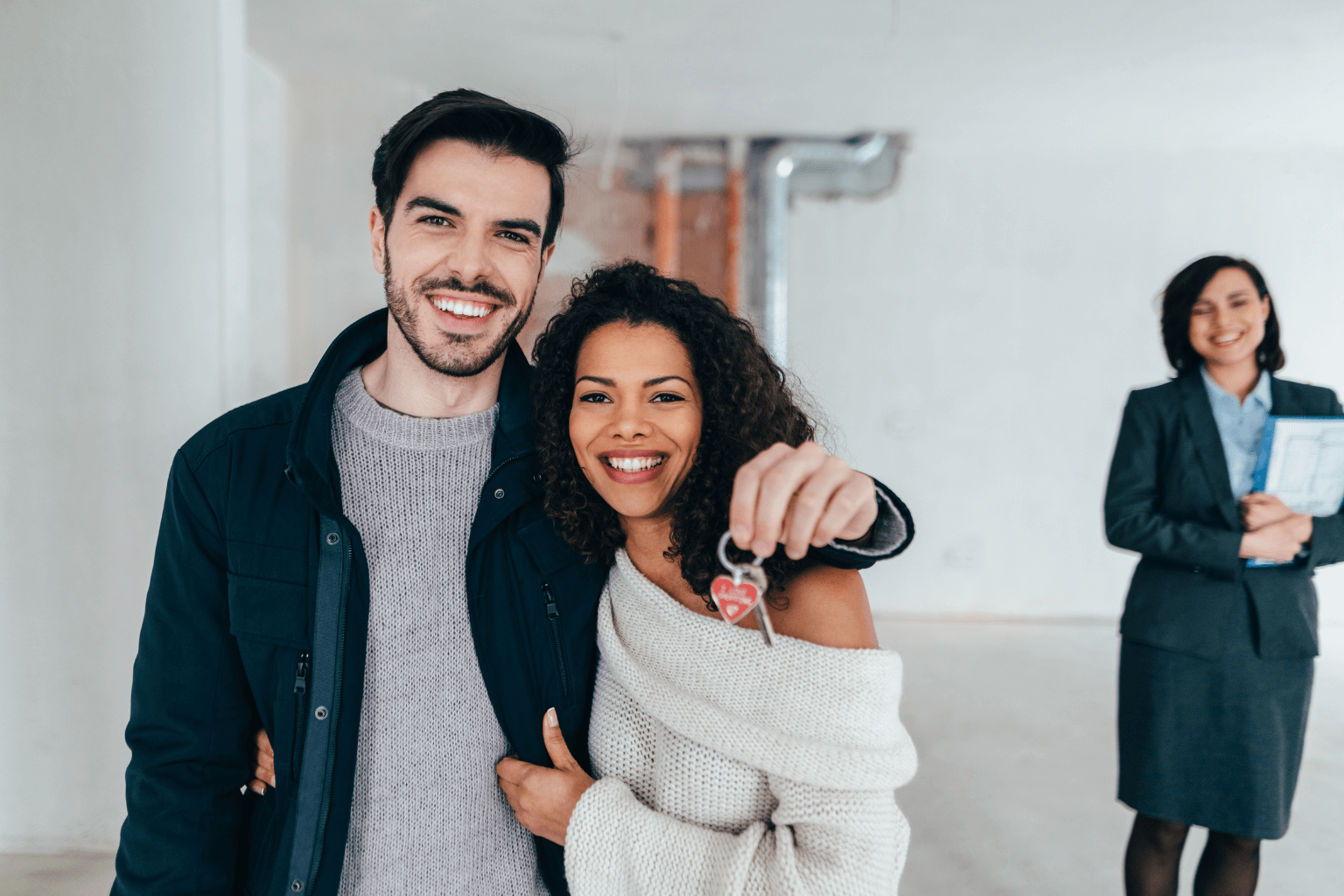 Smiling couple holding house keys in front of their new Orinda home