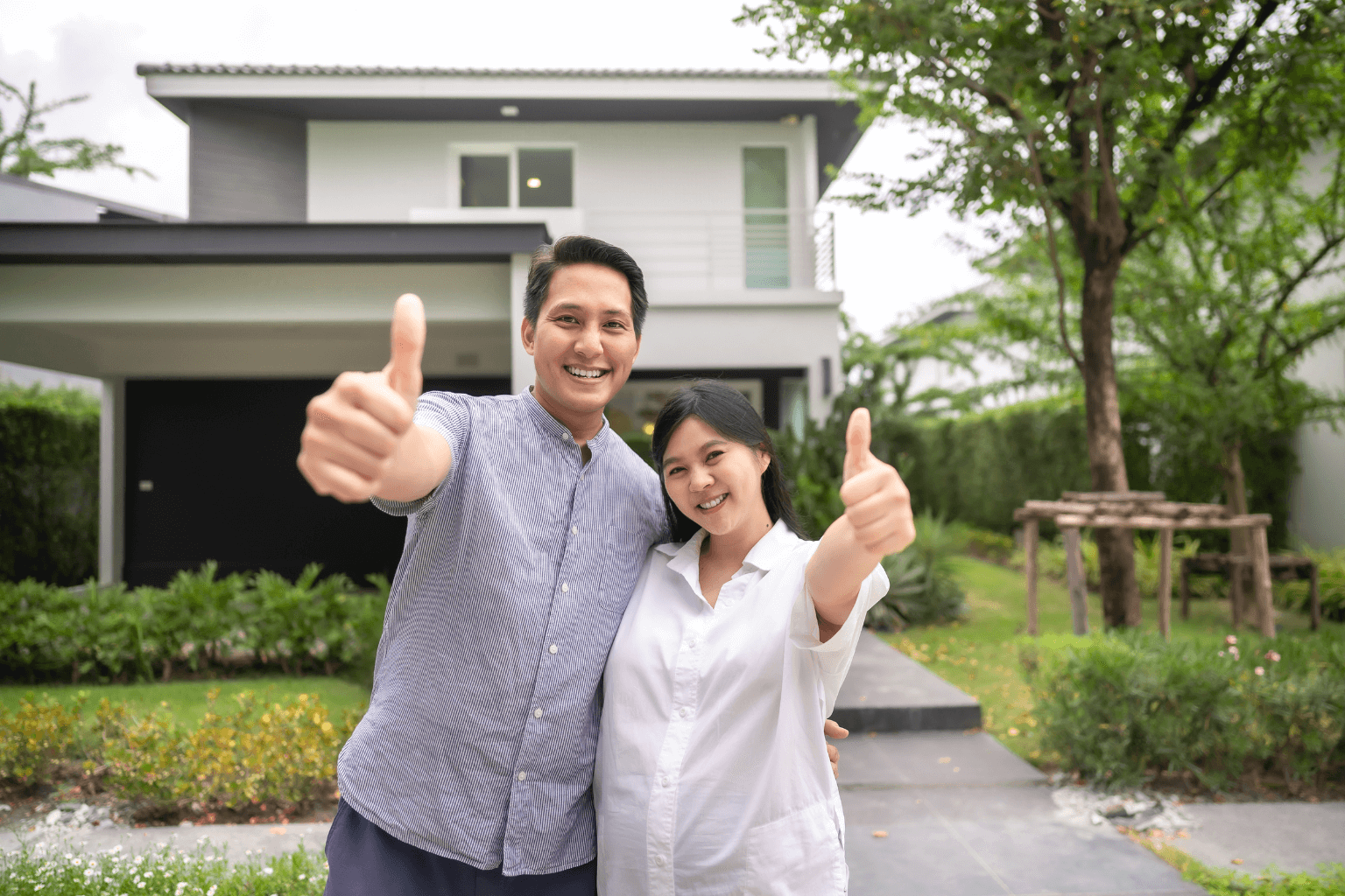 Happy couple standing in front of their new home in Concord California