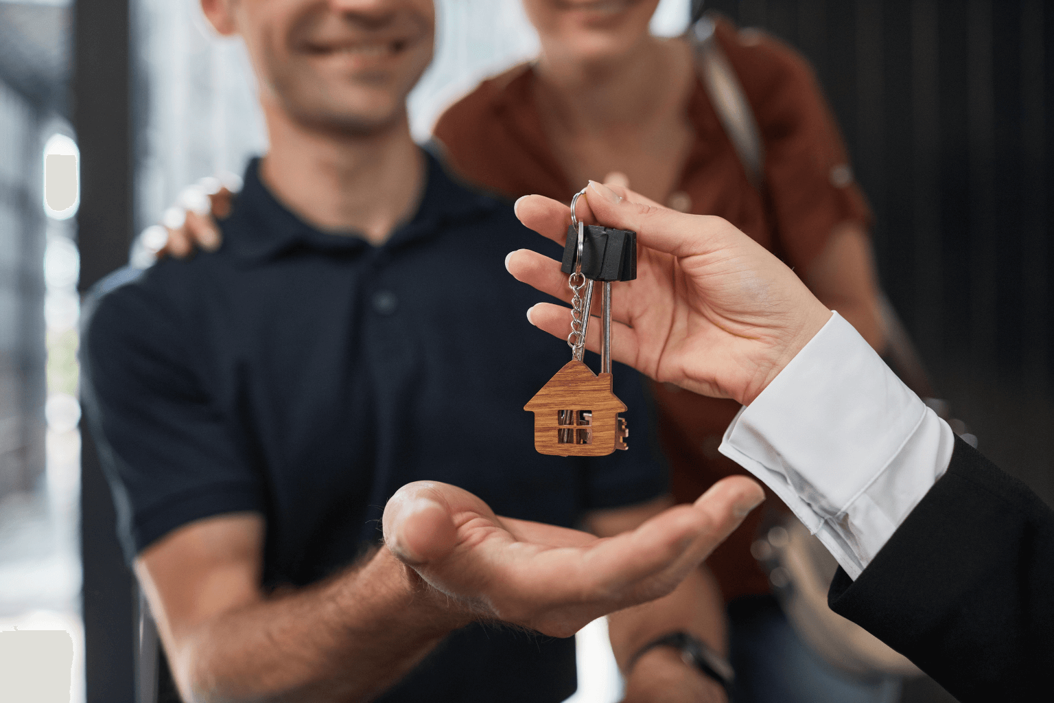 Happy homebuyers receiving keys from their Pleasanton realtor