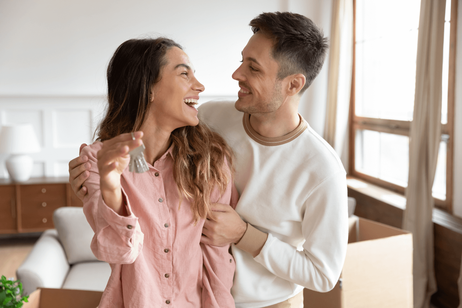 Happy couple standing in their new home