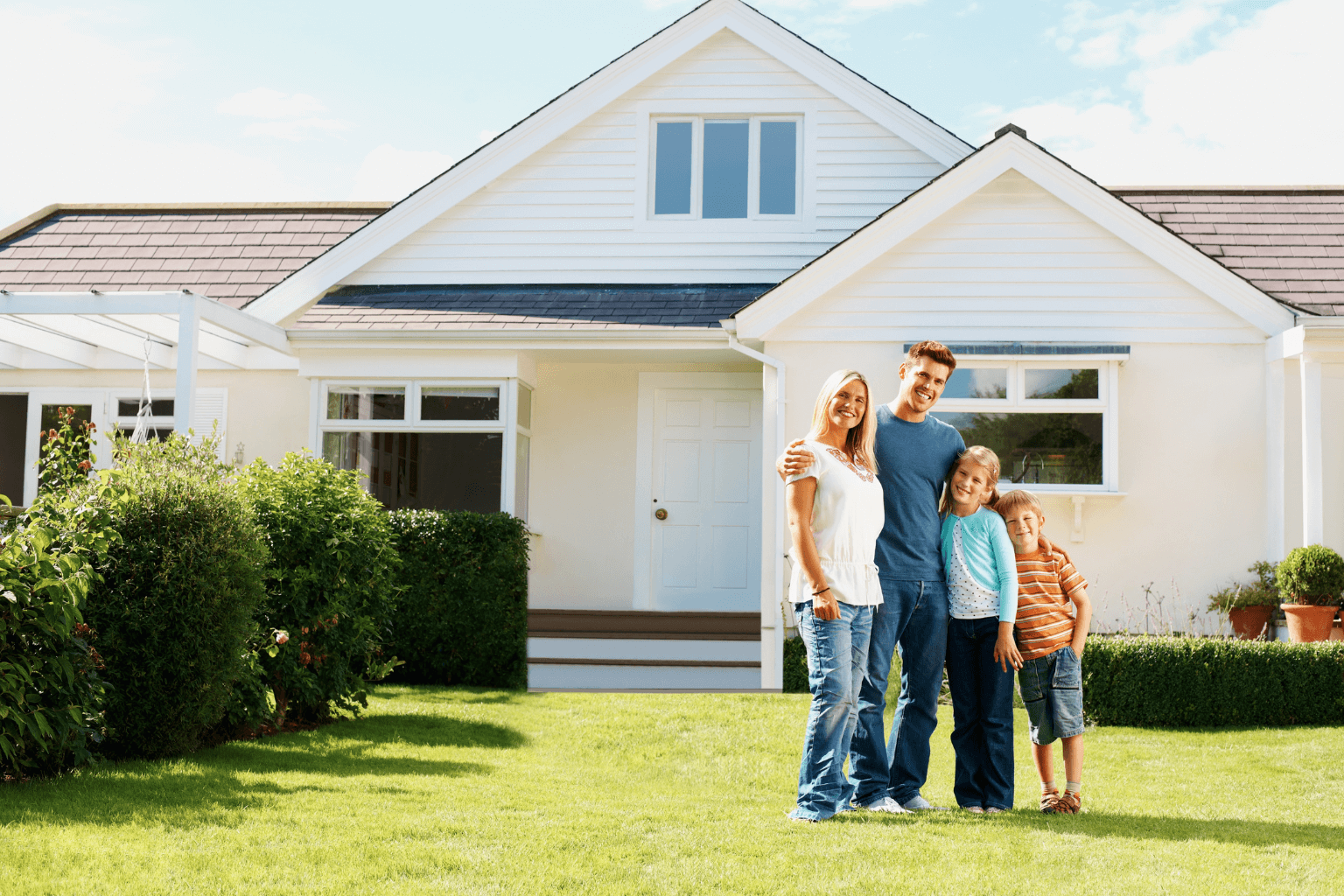 Happy family standing outside their new home in a suburban neighborhood