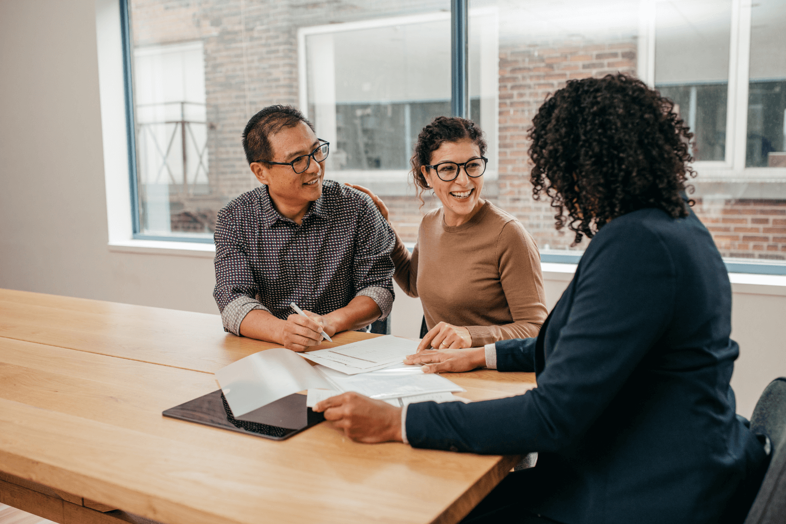 Couple discussing real estate listings with an agent 
