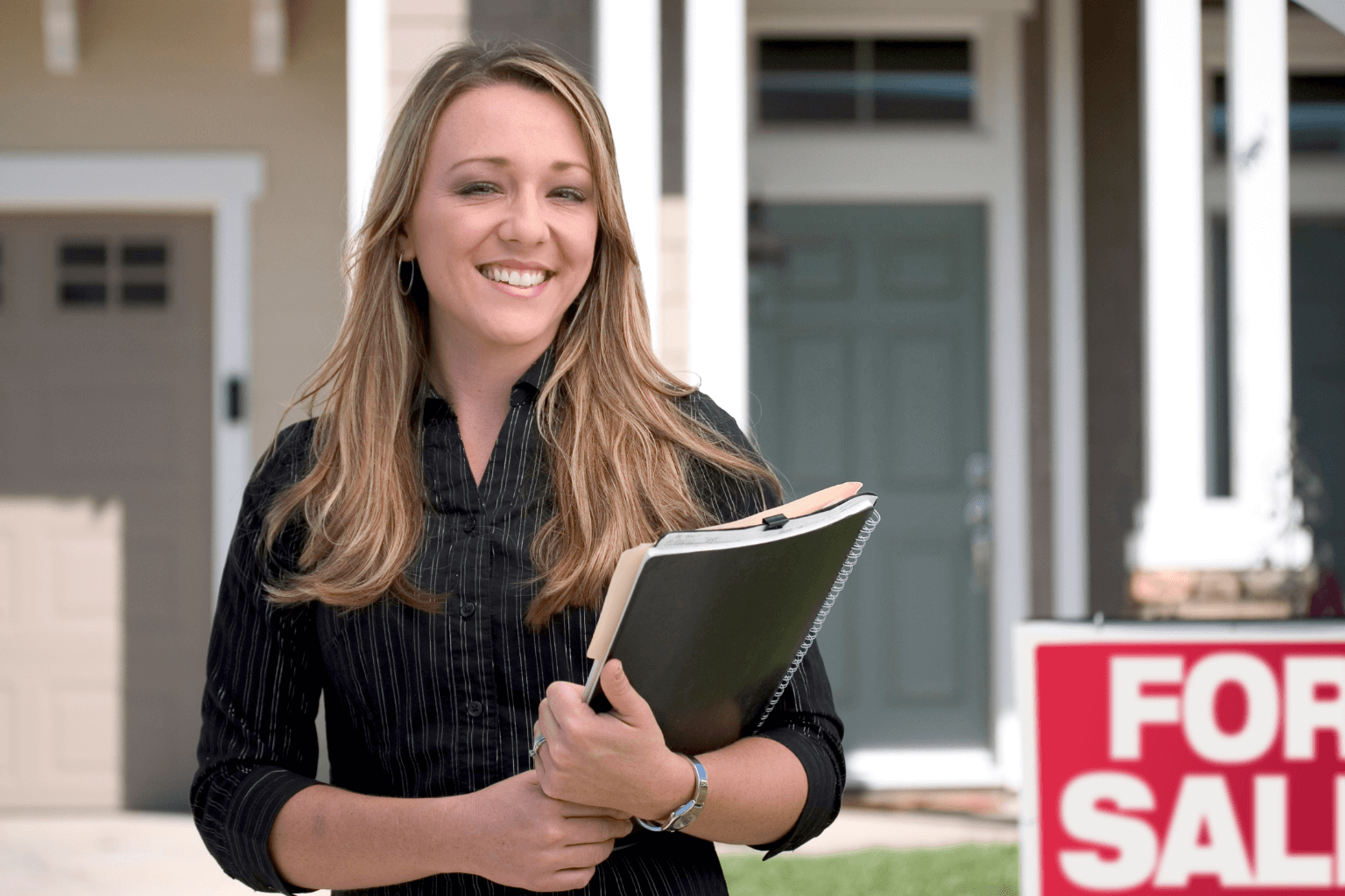 A real estate agent standing in front of a house