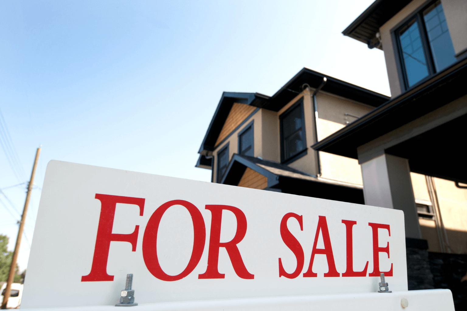 Modern home with a for sale sign in front