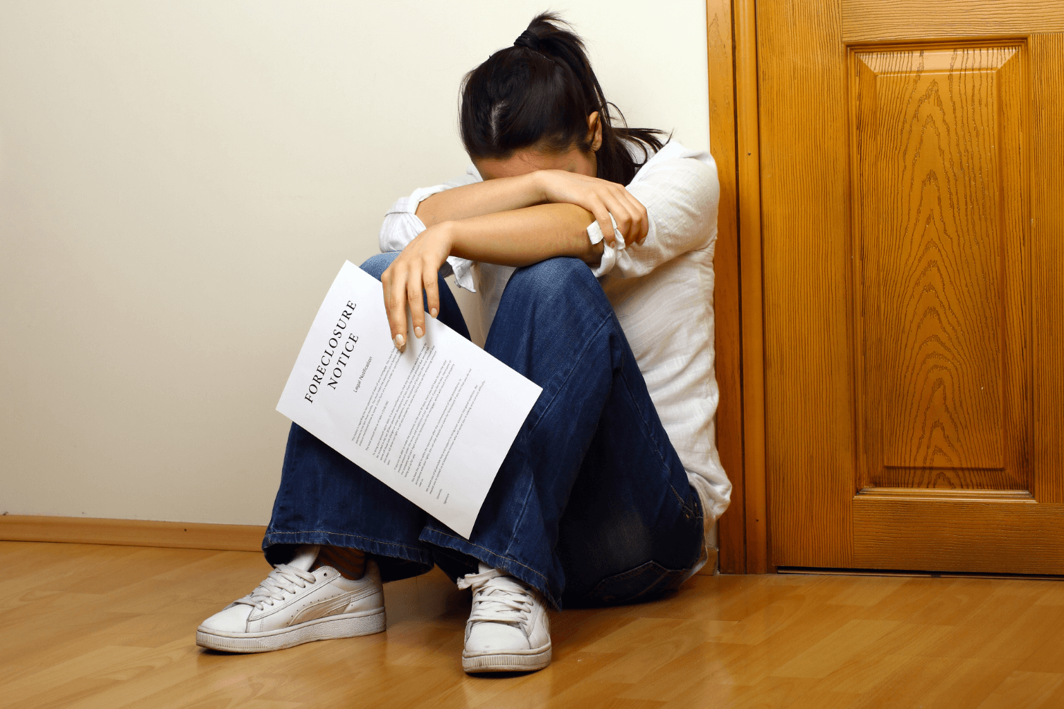 Woman holding foreclosure notice in her living room