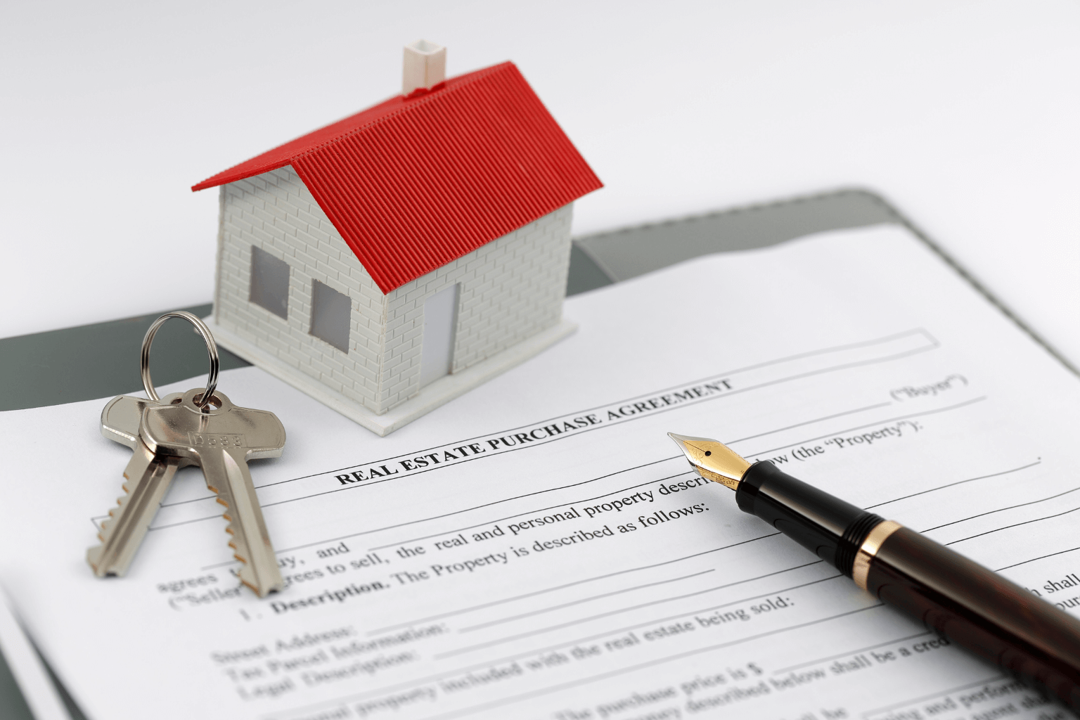 real estate paperwork with a pen and key