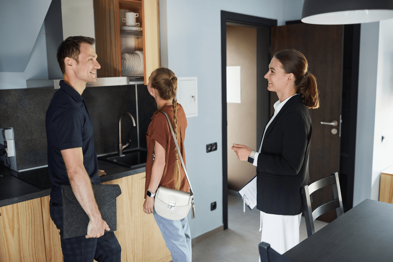 Real estate agent showing a couple a house interior
