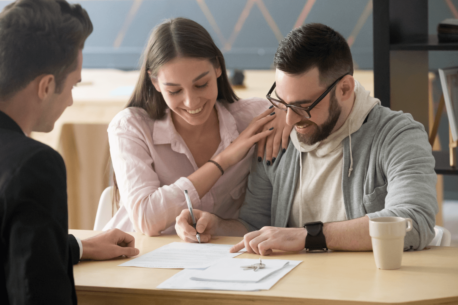 Happy couple reviewing home buying paperwork at a table