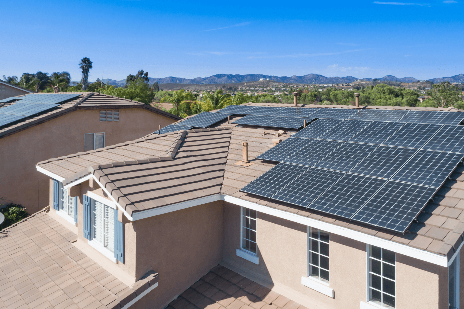 Home with rooftop solar panels under blue sky