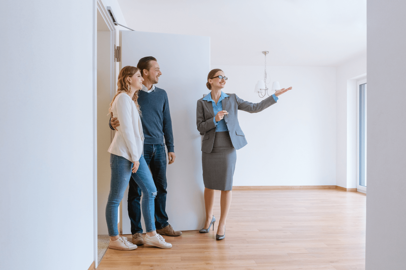Couple walking through home with real estate agent