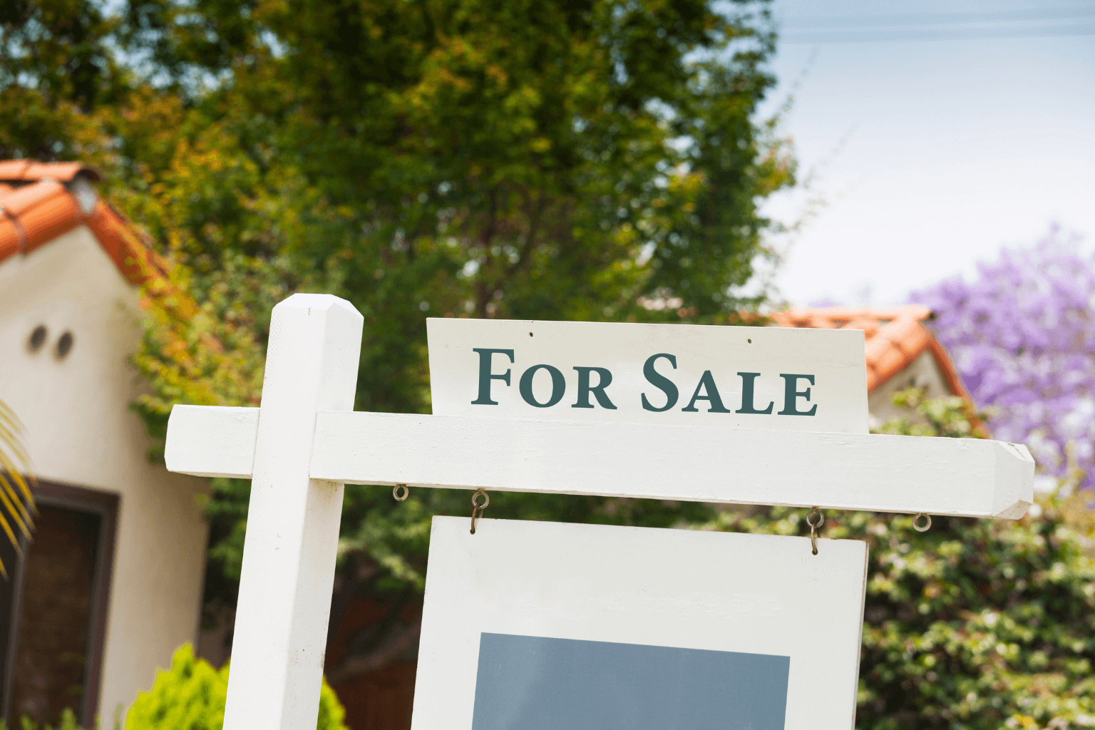 For sale sign in front of a suburban home