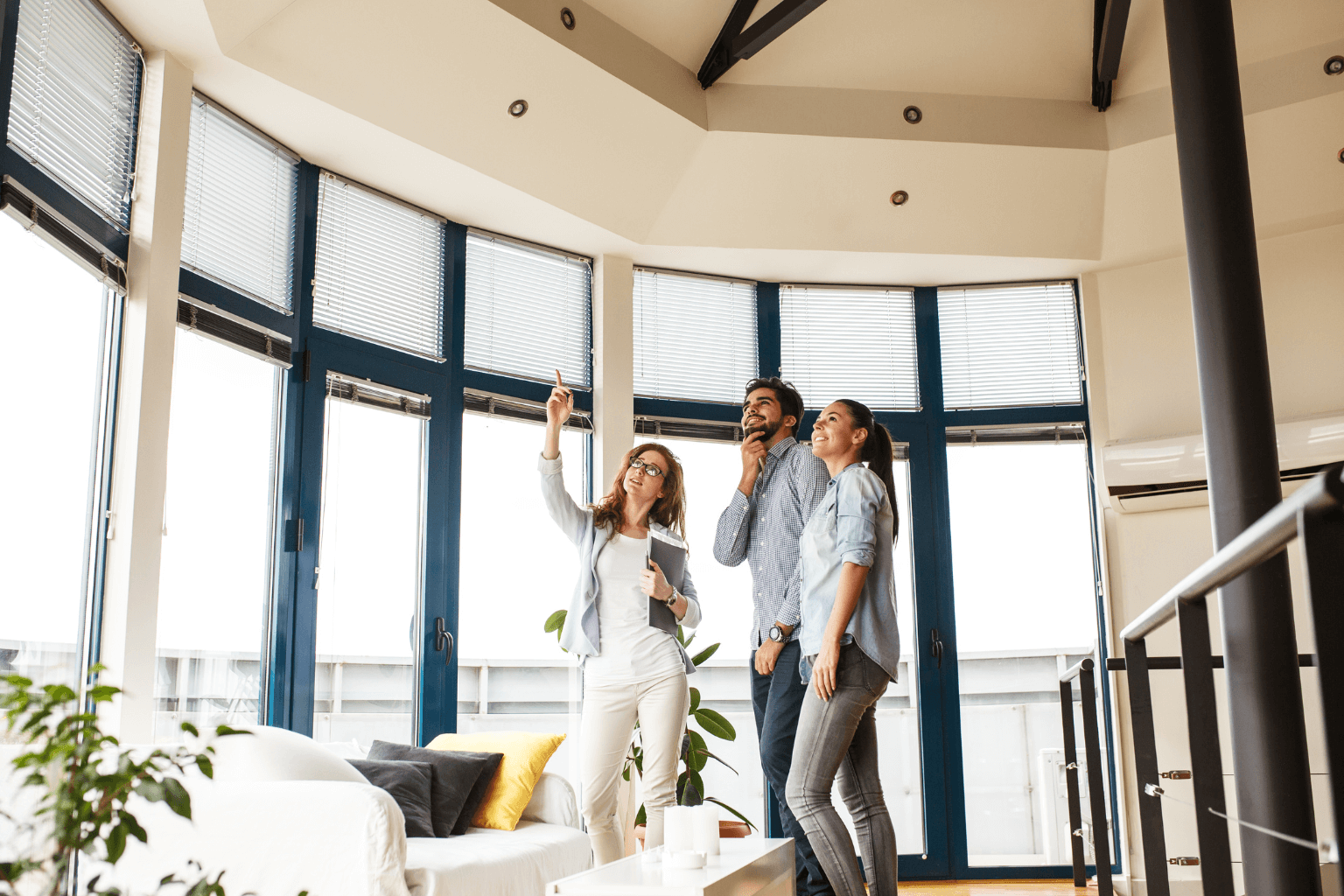 Realtor giving clients a property tour in the afternoon.