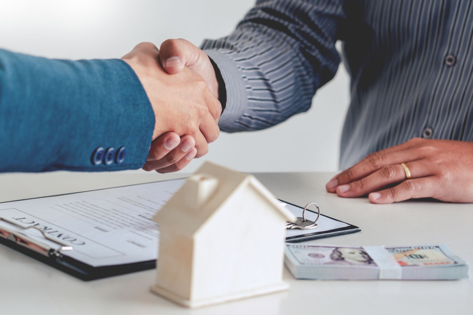 Happy homebuyers shaking hands after purchasing a house in Danville California.