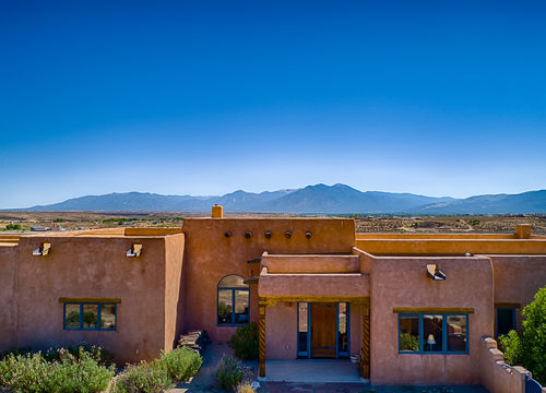Adobe home in Ranchos de Taos, NM with mountain views and Southwestern architecture, showcasing Northern New Mexico real estate.