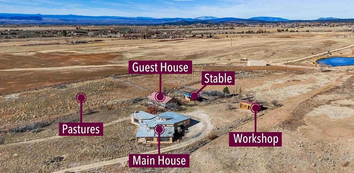 Aerial photograph of a renovated horse property in Arroyo Seco, New Mexico, with labeled main house, guest house, stable, workshop, and pastures, surrounded by open mountain views.