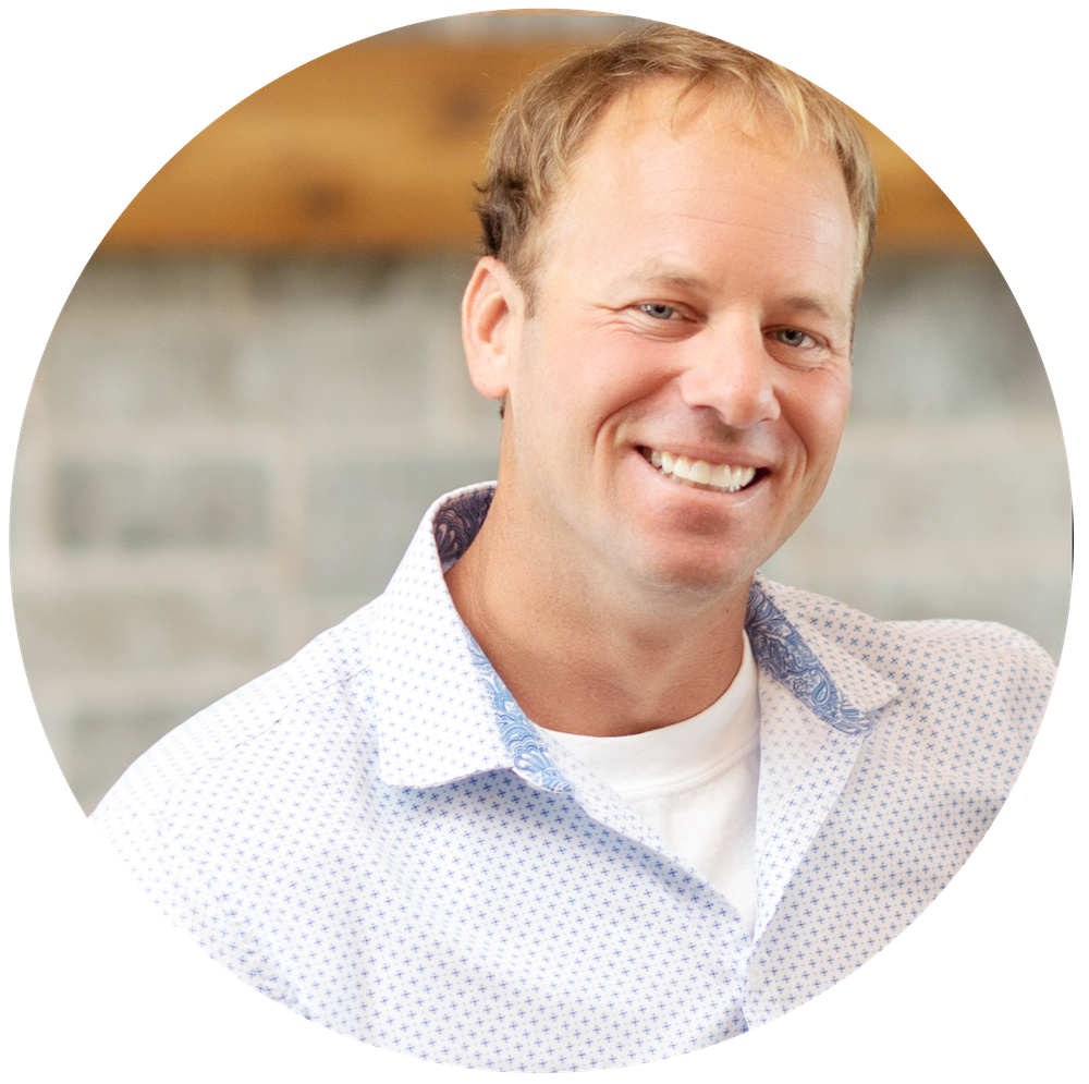 Portrait of Tim Booth, Realtor at Piper Creek Realty in Rockwall, Texas, smiling in a light patterned shirt against a soft, modern background.