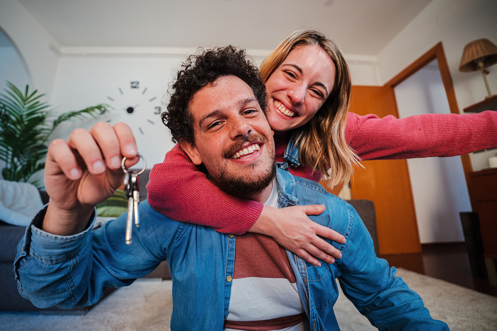 Young Caucasian Couple Showing Keys Of Their First House After P