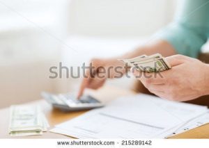 stock-photo-savings-finances-economy-and-home-concept-close-up-of-man-with-calculator-counting-money-and-215289142