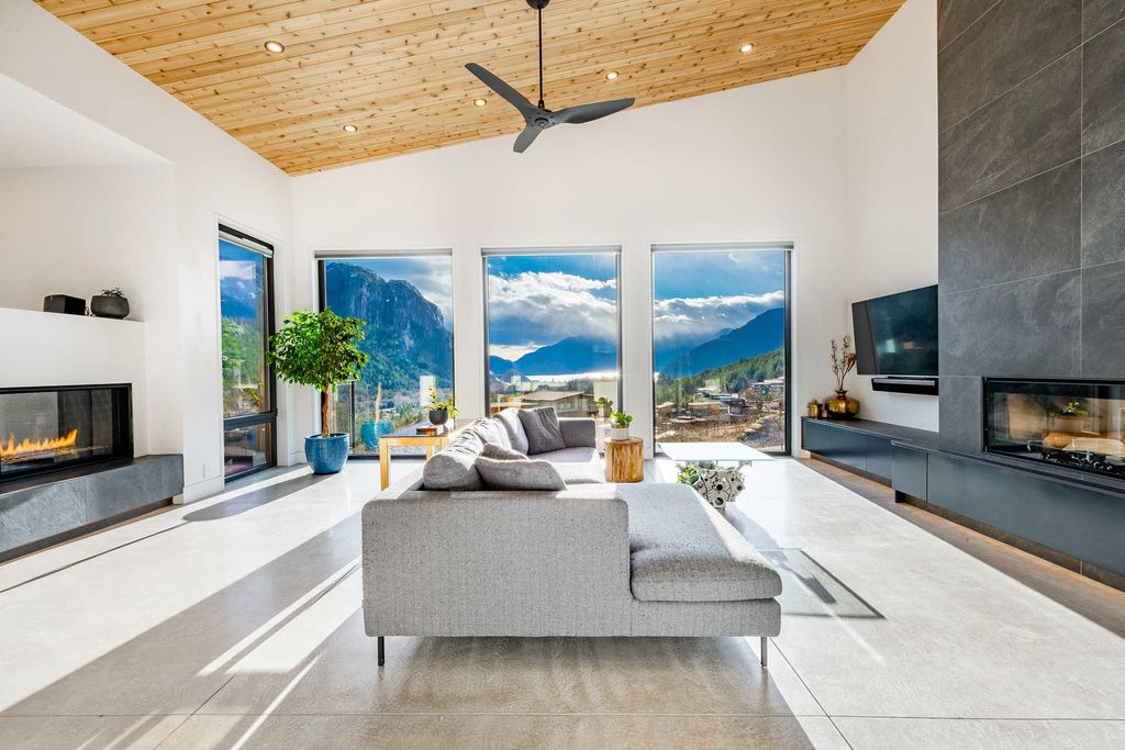A bright living room with a wall of windows facing the mountains
